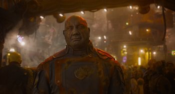 Movie still from “Guardians of the Galaxy Vol. 3” (2023), directed by James Gunn – An old man in a suit is standing in a dimly - lit room; Close Up shot, Low angle