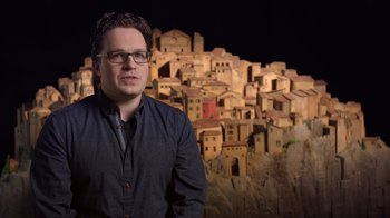 Movie still from “Guillermo del Toro's Pinocchio” (2022), directed by Guillermo del Toro – A man standing in front of a model of a city; Medium shot, Over the shoulder angle