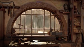 Movie still from “Guillermo del Toro's Pinocchio” (2022), directed by Guillermo del Toro – An arched window in a room with a wooden frame; Extreme Close Up shot, Low angle