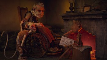 Movie still from “Guillermo del Toro's Pinocchio” (2022), directed by Guillermo del Toro – An old man sitting in a wheel chair next to a fire place; Wide shot, Low angle