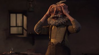 Movie still from “Guillermo del Toro's Pinocchio” (2022), directed by Guillermo del Toro – An old man with a long beard is holding his hands to his head; Close Up shot, Low angle
