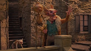 Movie still from “Guillermo del Toro's Pinocchio” (2022), directed by Guillermo del Toro – A man and a wooden puppet stand next to each other; Wide shot, Low angle
