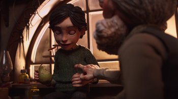 Movie still from “Guillermo del Toro's Pinocchio” (2022), directed by Guillermo del Toro – A person holding an apple in their hand; Medium shot, Over the shoulder angle