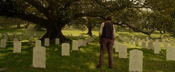 Movie still from “Hacksaw Ridge” (2016), directed by Mel Gibson – A man standing in front of a grave in a cemetery; Wide shot, Over the shoulder angle