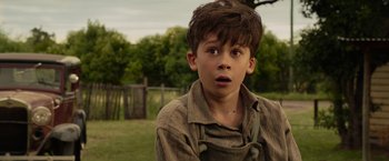 Movie still from “Hacksaw Ridge” (2016), directed by Mel Gibson – A young boy with a surprised look on his face; Close Up shot, Over the shoulder angle
