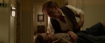 Movie still from “Hacksaw Ridge” (2016), directed by Mel Gibson – A man and a boy are in a room together; Medium shot, Low angle