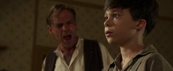 Movie still from “Hacksaw Ridge” (2016), directed by Mel Gibson – A man and a young boy are standing next to each other; Close Up shot, Over the shoulder angle