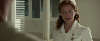 Movie still from “Hacksaw Ridge” (2016), directed by Mel Gibson – A woman in a nurse's uniform standing in front of a window; Close Up shot, Low angle