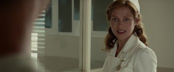Movie still from “Hacksaw Ridge” (2016), directed by Mel Gibson – A woman in a lab coat standing in front of a window; Close Up shot, Over the shoulder angle