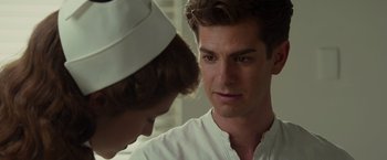 Movie still from “Hacksaw Ridge” (2016), directed by Mel Gibson – A man in a nurse's hat looking at another man; Close Up shot, Over the shoulder angle