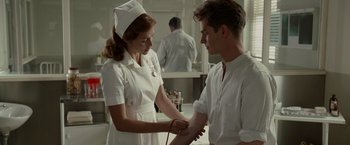 Movie still from “Hacksaw Ridge” (2016), directed by Mel Gibson – A woman in a nurse's uniform and a man in a white shirt; Medium shot, Low angle