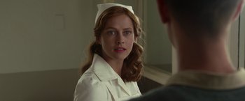 Movie still from “Hacksaw Ridge” (2016), directed by Mel Gibson – A woman in a nurse's uniform looking at the camera; Close Up shot, Over the shoulder angle