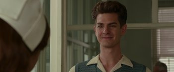 Movie still from “Hacksaw Ridge” (2016), directed by Mel Gibson – A man with a beard and a vest is smiling for the camera; Close Up shot, Over the shoulder angle