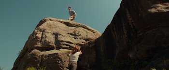 Movie still from “Hacksaw Ridge” (2016), directed by Mel Gibson – A man and a woman are climbing a rock wall; Extreme Wide shot, Low angle