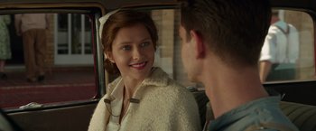 Movie still from “Hacksaw Ridge” (2016), directed by Mel Gibson – A young woman smiles at a young man in the back of a car; Close Up shot, Over the shoulder angle
