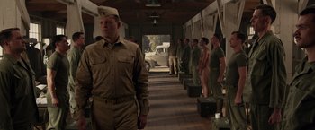 Movie still from “Hacksaw Ridge” (2016), directed by Mel Gibson – A group of men standing next to each other in a building; Wide shot, Over the shoulder angle