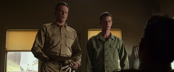 Movie still from “Hacksaw Ridge” (2016), directed by Mel Gibson – Two men standing next to each other in front of a wall; Medium shot, Low angle