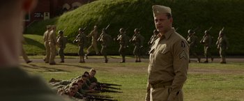 Movie still from “Hacksaw Ridge” (2016), directed by Mel Gibson – A group of men in uniform with guns in a field; Medium shot, Over the shoulder angle
