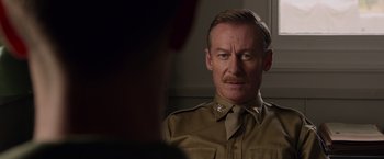 Movie still from “Hacksaw Ridge” (2016), directed by Mel Gibson – A person wearing a military uniform; Close Up shot, Over the shoulder angle