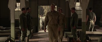 Movie still from “Hacksaw Ridge” (2016), directed by Mel Gibson – A group of men in uniform walking through a building; Wide shot, Low angle