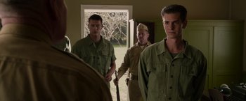 Movie still from “Hacksaw Ridge” (2016), directed by Mel Gibson – A group of men standing next to each other in front of a window; Medium shot, Over the shoulder angle