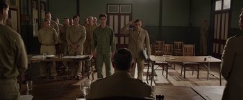 Movie still from “Hacksaw Ridge” (2016), directed by Mel Gibson – A group of men in uniform saluting in a room; Wide shot, Low angle