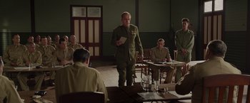 Movie still from “Hacksaw Ridge” (2016), directed by Mel Gibson – A man in a military uniform standing in front of a group of people; Wide shot, Over the shoulder angle