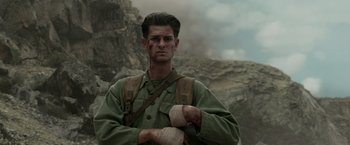 Movie still from “Hacksaw Ridge” (2016), directed by Mel Gibson – A man with bandages on his arms and face; Close Up shot, Low angle