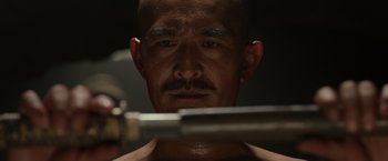 Movie still from “Hacksaw Ridge” (2016), directed by Mel Gibson – A bald man with a mustache looking at himself in the mirror; Close Up shot, Low angle