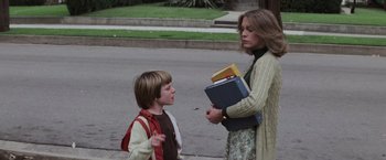 Movie still from “Halloween” (1978), directed by John Carpenter – A woman and a boy standing on the side of a road; Medium shot, Over the shoulder angle