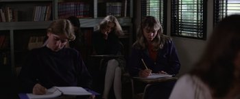 Movie still from “Halloween” (1978), directed by John Carpenter – A group of people sitting in a room with books; Medium shot, High angle