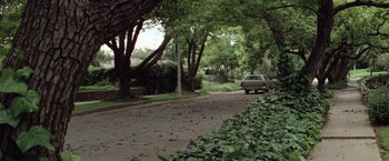 Movie still from “Halloween” (1978), directed by John Carpenter – A car parked on the side of the road near some trees; Wide shot, Low angle