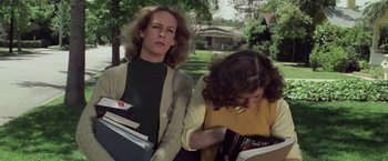Movie still from “Halloween” (1978), directed by John Carpenter – Two women standing next to each other holding books; Medium shot, Low angle