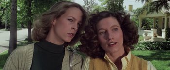 Movie still from “Halloween” (1978), directed by John Carpenter – Two women posing for a picture in front of trees; Close Up shot, Low angle