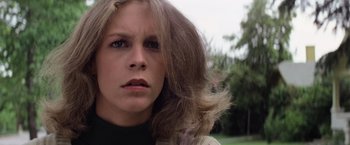 Movie still from “Halloween” (1978), directed by John Carpenter – A person's face with long hair; Close Up shot, Low angle