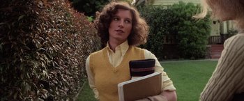 Movie still from “Halloween” (1978), directed by John Carpenter – A woman in a yellow sweater holding a book and purse; Close Up shot, Low angle