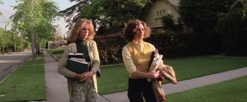 Movie still from “Halloween” (1978), directed by John Carpenter – Two women walking down a sidewalk holding papers; Medium shot, Low angle