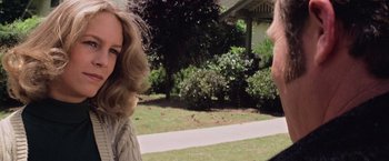 Movie still from “Halloween” (1978), directed by John Carpenter – Two people standing in front of each other on a sidewalk; Close Up shot, Over the shoulder angle