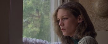 Movie still from “Halloween” (1978), directed by John Carpenter – A woman sitting in front of a window looking sad; Close Up shot, Low angle