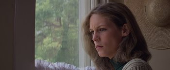 Movie still from “Halloween” (1978), directed by John Carpenter – A person looking out a window; Close Up shot, Low angle
