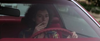 Movie still from “Halloween” (1978), directed by John Carpenter – A woman sitting in the driver's seat of a car smoking; Close Up shot, High angle