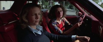 Movie still from “Halloween” (1978), directed by John Carpenter – Two women sitting in the back seat of a red car; Close Up shot, Low angle