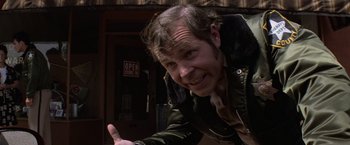 Movie still from “Halloween” (1978), directed by John Carpenter – A man in a jacket is smiling for the camera; Close Up shot, Low angle