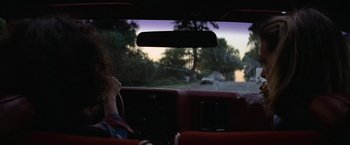 Movie still from “Halloween” (1978), directed by John Carpenter – A woman sitting in the driver's seat of a car looking out the window; Medium shot, Over the shoulder angle