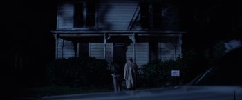 Movie still from “Halloween” (1978), directed by John Carpenter – Two men standing in front of a house at night; Wide shot, Low angle
