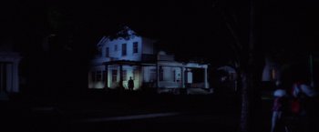 Movie still from “Halloween” (1978), directed by John Carpenter – A person standing in front of a house at night; Extreme Wide shot, Low angle