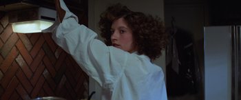 Movie still from “Halloween” (1978), directed by John Carpenter – A woman in a white shirt is holding her arms up; Close Up shot, Low angle