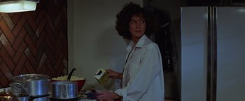 Movie still from “Halloween” (1978), directed by John Carpenter – A woman in a white shirt is holding a box of popcorn; Medium shot, Low angle
