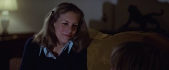 Movie still from “Halloween” (1978), directed by John Carpenter – A woman sitting on top of a couch next to a child; Close Up shot, Over the shoulder angle