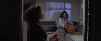 Movie still from “Halloween” (1978), directed by John Carpenter – Two women standing in a kitchen looking at each other; Medium shot, Over the shoulder angle